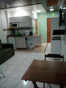 马瑙斯阿茹里卡巴8号公寓的厨房以及带沙发和桌子的客厅。
