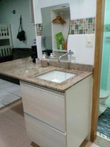 马瑙斯阿茹里卡巴8号公寓的厨房柜台设有水槽和冰箱