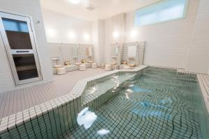 苫小牧市苫小牧杉田酒店的浴室设有大型水池和卫生间