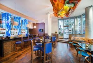波特兰波特兰旧港区凯悦嘉轩酒店的一间设有蓝色桌椅的餐厅和一间酒吧