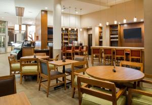 波特兰波特兰旧港区凯悦嘉轩酒店的用餐室配有木桌和椅子