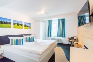 科齐扎尔滕地科隆贾尼酒店的配有一张床和一把椅子的酒店客房
