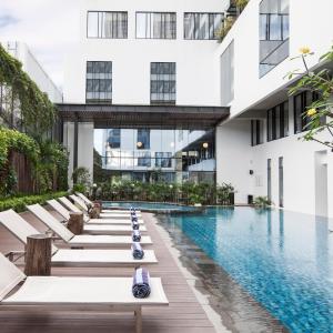日惹盖亚科兹摩酒店的一座带躺椅的建筑内的游泳池