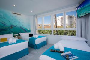 马拉加Casual del Mar Málaga的酒店客房带两张床和一个水族馆