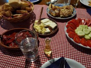 兹拉蒂博尔Etno kuće Boškova Voda的一张桌子,上面有盘子,放在红色和白色的桌布上