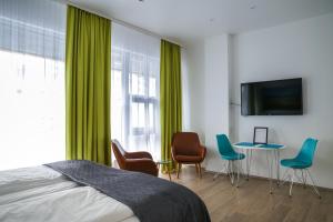 雷克雅未克Iceland Comfort Apartments by Heimaleiga的一间卧室配有绿色窗帘和桌椅