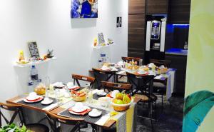 马赛马西利亚酒店的用餐室配有桌椅和食物