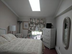 五月岬郡Inn At The Park - The Cottage的一间卧室设有一张床和一个窗口