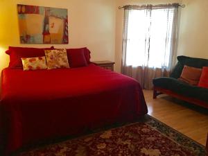 新布朗费尔斯River Run Retreat的一间卧室配有红色的床和一张沙发