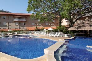 阿瓜斯迪林多亚曼托瓦尼酒店的一个带椅子和遮阳伞的大型游泳池