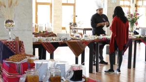 乌鲁班巴巴列萨格拉多塔皮卡拉豪华酒店的男人和女人站在餐桌上吃饭