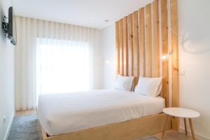 布拉加Bracara Guest House "D. Pedro V"的一间卧室配有一张带木制床头板的床