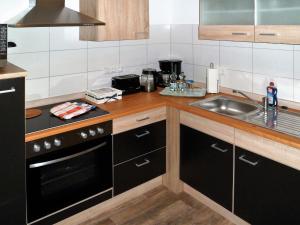 海因斯贝格Ferienwohnung Anke - Apartment 3c的厨房配有水槽和炉灶 顶部烤箱