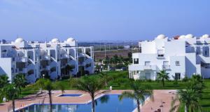 萨伊迪耶Chez Younès Appartement Marina Saidia Ap8的享有部分白色建筑和游泳池的景色
