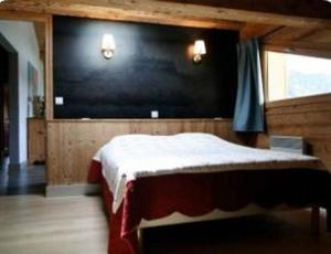 莱热阿尔卑斯花卉小屋酒店的一间卧室设有一张床和一张大型黑色墙壁