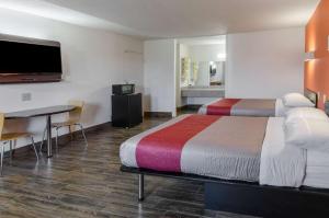斯汤顿士丹顿第6汽车旅馆的一间酒店客房,设有两张床、一张桌子和一台电视机