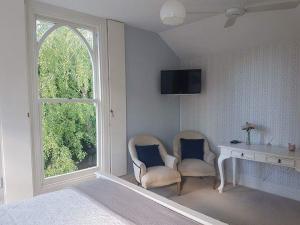 格雷敦萨多勒里乡村别墅的一间卧室配有两把椅子、一张桌子和一个窗户