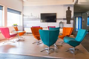 摩城莫城弗约得加登酒店的一间会议室,配有五颜六色的椅子和桌子