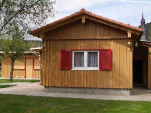 NeustadtBerliner Huette的一个小房子,有窗户和红色百叶窗