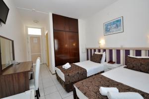 马尔马里斯Reis Maris Hotel的酒店客房设有两张床和电视。