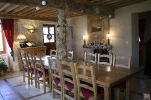 Saint-Martin-en-VercorsLa ferme du Château的一间带木桌和椅子的用餐室