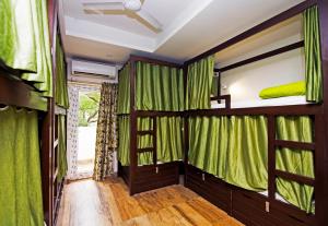 新德里Joey's Hostel Delhi的一间设有绿色窗帘和双层床的客房