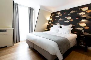 巴黎香榭丽舍大道马西斯酒店的一间卧室设有一张大床和黑色墙壁