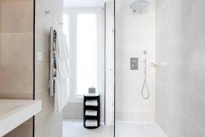 巴黎香榭丽舍大道马西斯酒店的带淋浴的白色浴室和窗户。