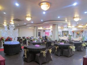 坤甸坤甸梅尔帕提酒店的宴会厅配有桌椅和鲜花