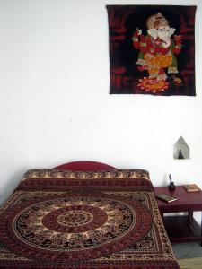 克久拉霍Friends in Khajuraho的床上的地毯,墙上有绘画作品