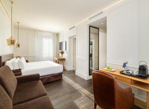 巴塞罗那精品酒店蒙特卡达H10的配有一张床和一张书桌的酒店客房