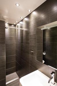 迪温特Luxe B&B Het Colmerhof的带淋浴、水槽和镜子的浴室