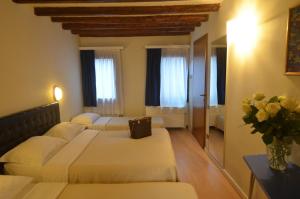 威尼斯小提埃波罗旅馆的酒店客房,设有两张床和一张沙发