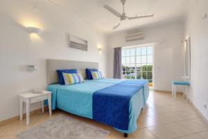 阿尔布费拉3HB Clube Humbria - All Inclusive的一间卧室设有蓝色的床和窗户。