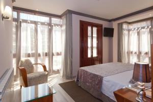 奥维多维图什塔酒店的一间卧室配有一张床、一把椅子和窗户。