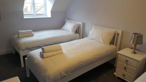 FeltonThe George & Dragon的配有2张单人床的客房设有床头柜和窗户。