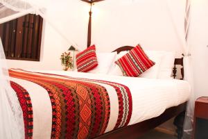 高尔布利斯堡酒店的一张带红色和白色枕头的床