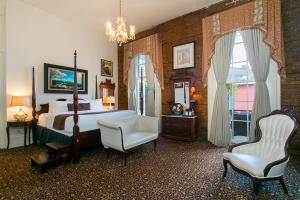 新奥尔良Lafitte Hotel & Bar的卧室配有床、椅子和窗户。