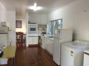 拉罗汤加莱那假日公寓的铺有木地板的厨房配有白色家电