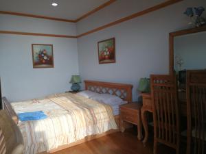 班佩罗勇市泰式风格VIP公寓的一间卧室配有一张床、梳妆台和镜子