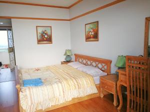 班佩罗勇市泰式风格VIP公寓的一间卧室配有一张床、床头柜和一张桌子