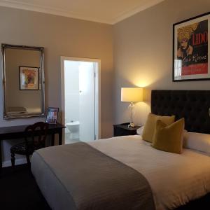 Hamilton北方之星酒店的一间卧室配有一张床、镜子和一张书桌
