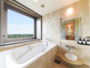 AkishimaForest Inn Showakan (Okura Hotels & Resorts)的一间带大浴缸和窗户的浴室