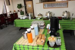 东广岛市东广岛西条山酒店的一张桌子,上面有绿色桌子和食物