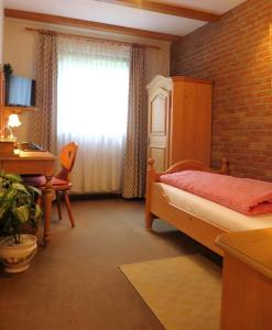 埃森佳斯格博酒店的一间卧室配有一张床、一张书桌和一个窗户。