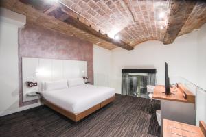 巴塞罗那佩蒂特宫波盖利亚花园酒店的一间卧室配有一张床、一张桌子和一个壁炉