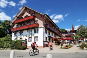 施卢赫湖Wochner's Hotel-Sternen Am Schluchsee Hochschwarzwald的两人骑车在大楼前