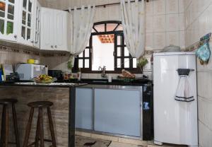 卡舒埃拉保利斯塔Casa & Hospedagem Carol的厨房配有水槽和冰箱