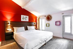 戛纳米斯特拉尔酒店的一间卧室设有一张红色墙壁的大床