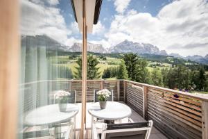 拉维拉Alpine Hotel Ciasa Lara的山景阳台,配有2张桌子。